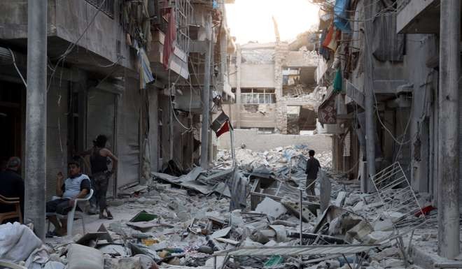 Locals look at the damage from an air strike in the rebel-held al-Qaterji neighbourhood of Aleppo. Photo: Reuters
