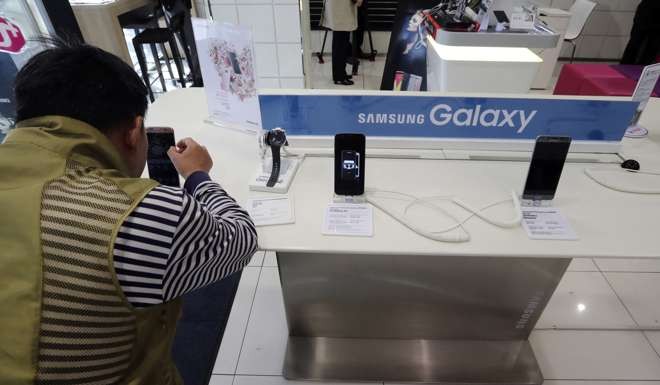 A visitor tries the Samsung Electronics' S7 edge smartphone at a shop of South Korean mobile carrier in Seoul, South Korea. Photo: AP