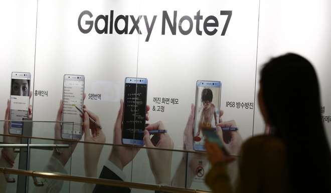 A South Korean woman walks next to an advertisement of the Samsung Galaxy Note 7 at the Samsung Electronics headquarters in Seoul, South Korea. Photo: EPA