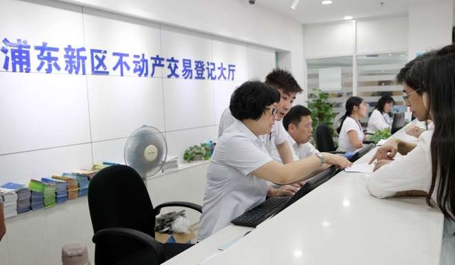 Property registrations are logged by staff at a government office in Shanghai on October 8, 2016. Photo: Xinhua