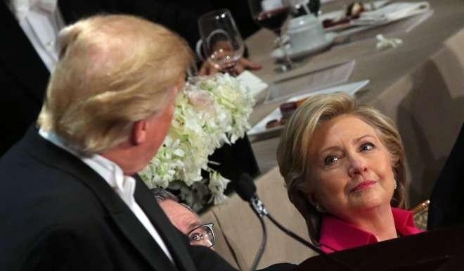 Democratic US presidential nominee Hillary Clinton looks at Republican nominee Donald Trump as he speaks during the Alfred E. Smith Memorial Foundation dinner. Photo: Reuters