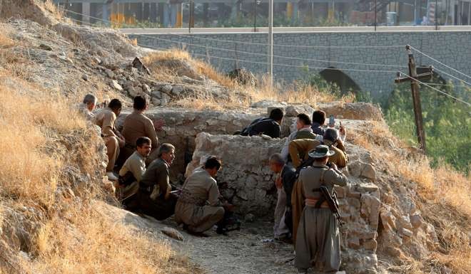 Kurdish forces take cover after Islamic State militants launched a major attack on the city of Kirkuk. Photo: Reuters