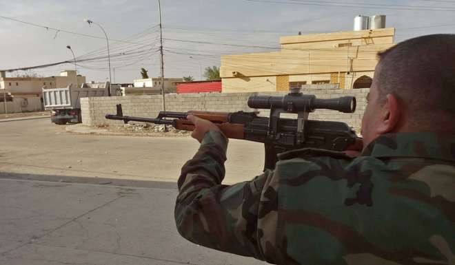 A member of the Iraqi Kurdish security forces aims his weapon in the southern Domiz neighbourhood of Kirkuk. Photo: AFP