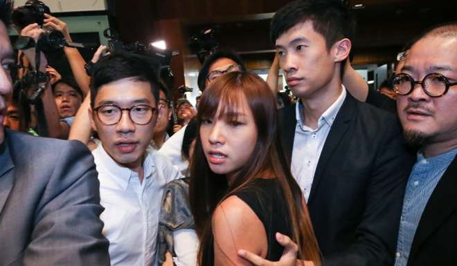 Pan-democratic lawmakers including Nathan Law (left) escort Yau Wai-ching (centre) and Baggio Leung (right) into the Legco chamber Photo: Sam Tsang