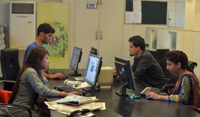 Pakistani staff of Islamabad-based Power 99 FM radio work on their computers at the radio station's office in Islamabad. Photo: AFP