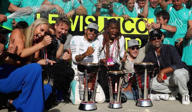 Lewis Hamilton celebrates his win with Nico Rosberg of Germany and Mercedes GP, skier Lindsey Vonn, chef Gordon Ramsey, tennis superstar Venus Williams at Circuit of The Americas.