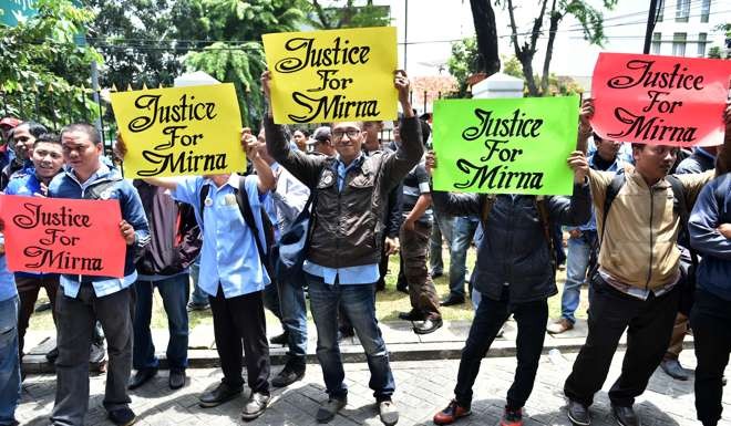 Relatives of victim Wayan Mirna Salihin hold signs outside the Central Jakarta court. Photo: AFP