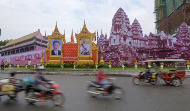 Motorists pass portraits of China’s President Xi Jinping, left, and Cambodia’s King Norodom Sihamoni in Phnom Penh before Xi’s visit to the country earlier this month. Photo: AFP