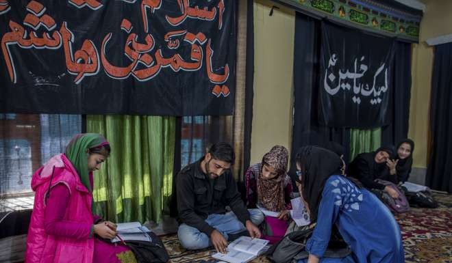 Mohammad Hussain teaches Kashmiri girls in an ad-hoc learning centre, set up in a building meant for religious activity in Srinagar. Photo: AP