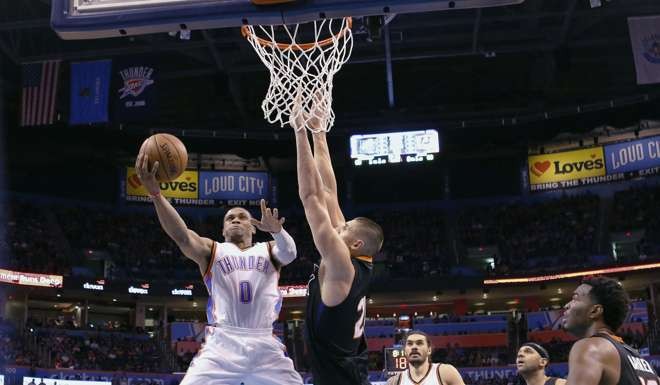 Oklahoma City Thunder guard Russell Westbrook (0) goes up for a basket as Phoenix Suns center Alex Len (21) defends. (AP Photo/Alonzo Adams)