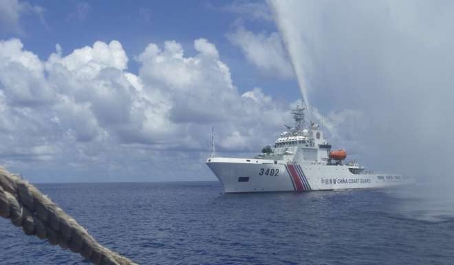A Chinese Coast Guard ship fires water cannon at Filipino fishing vessels off Scarborough Shoal in 2015. For the first time in years it appears China has allowed Filipinos to fish there unhindered. File photo: AP