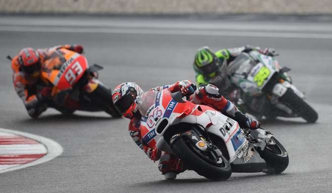 Andrea Dovizioso rides ahead of LCR Honda's British rider Cal Crutchlow (right) and Repsol Honda Team's Spanish rider Marc Marquez (left) in wet conditions during the Malaysian MotoGP. Photo: AFP