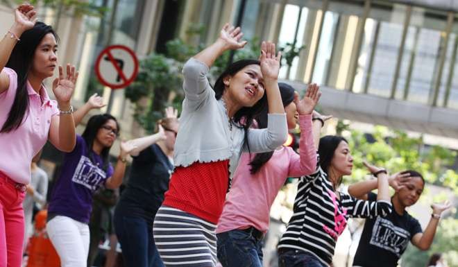 Filipino domestic workers dance in Central. The report highlighted a darker side to their lives. Photo: Nora Tam