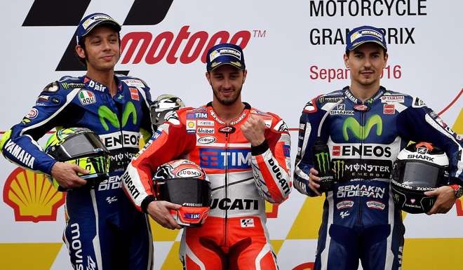 Andrea Dovizioso (centre) poses on the podium with second-placed Italian rider Valentino Rossi (left) and third-placed Spanish rider Jorge Lorenzo (right). Photo: AFP