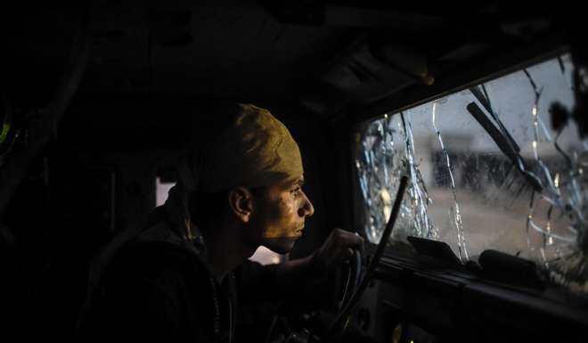 An Iraqi Counter Terrorism Section member drives a vehicles with a broken windscreen as they advance early in the morning near the village of Bazwaya. Photo: AFP