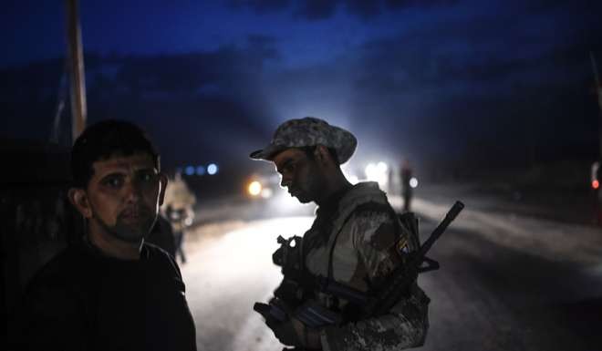 Members of the Iraqi Counter Terrorism Service prepare to attack near the village of Bazwaya. Photo: AFP