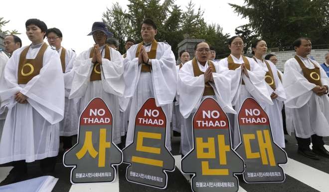 Buddhist monks pray during a rally to oppose deployment of the Thaad missile defence system, in front of the defence ministry in Seoul on September 30. Photo: AP