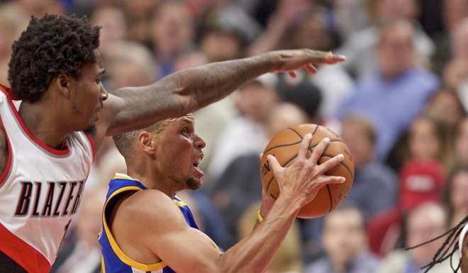 Golden State Warriors guard Stephen Curry, right, shoots as Portland Trail Blazers forward Ed Davis, left, defends during the second half of an NBA basketball game in Portland, Ore., Tuesday, Nov. 1, 2016. (AP Photo/Craig Mitchelldyer)