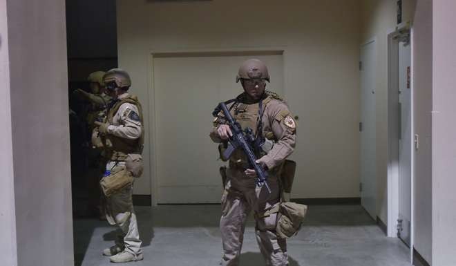 Heavily-armed police guard a bathroom where Austyn Crites was held. Photo: AFP