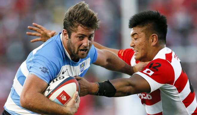 Santiago Cordero of Argentina heads for the try line, despite the attentions of Harumichi Tatekawa.