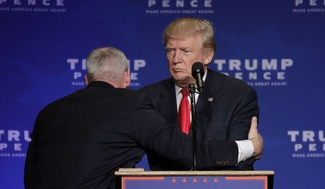 A member of the Secret Service pulls Trump from the stage. Photo: AP