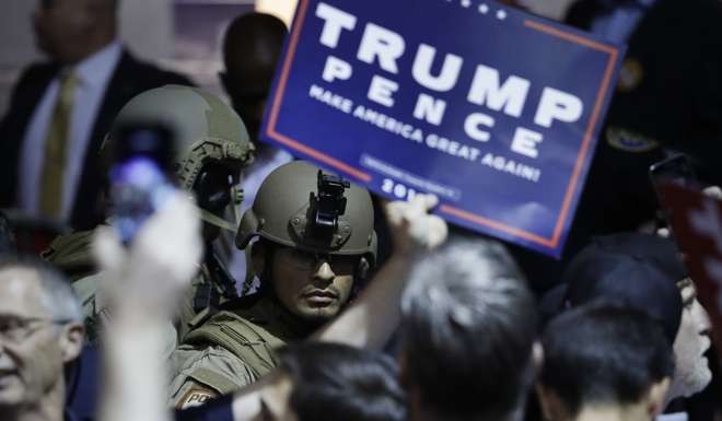 Armed law enforcement officers stand in the crowd moments after Trump was rushed offstage. Photo: AP