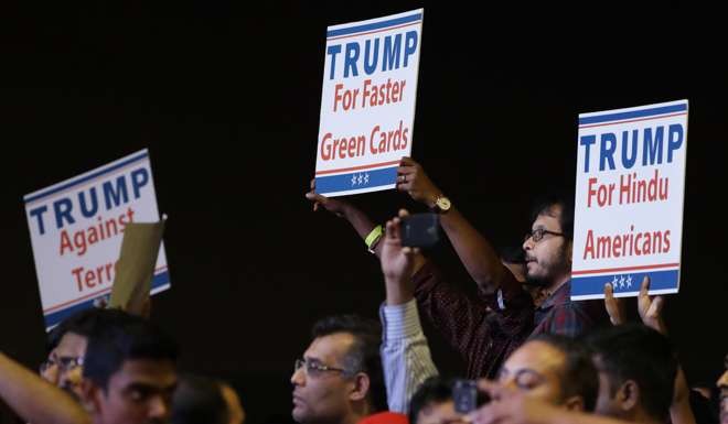 Supporters of Republican presidential candidate Donald Trump hold up signs as he speaks during a charity event hosted by the Republican Hindu Coalition in Edison, New jersey. Photo: AP