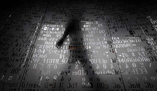 An employee walking behind a glass wall with coding symbols at the headquarters of Internet security giant Kaspersky in Moscow. Photo: AFP