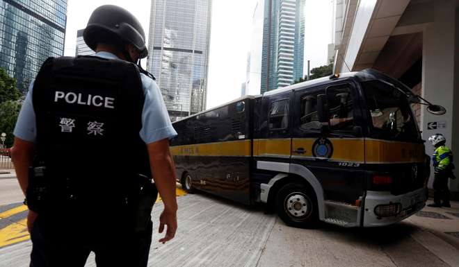 Armed policemen guard the entrance as a prison car carrying British former banker Rurik Jutting enters High Court in Hong Kong. Photo: Reuters