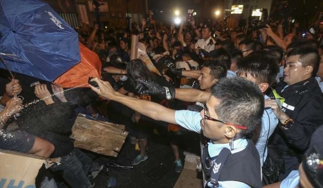 Police using pepper spray outside the central government’s liaison office early Monday. Photo: K. Y. Cheng