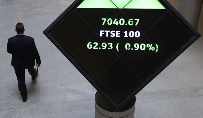 The share price of the FTSE 100 index is displayed on an illuminated rotating cube in the atrium of the London Stock Exchange Group Plc's offices in London. Photo: Bloomberg