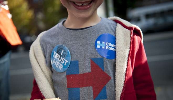 A young Hillary Clinton supporter stands outside a polling location for the 2016 US presidential election after polls opened in Philadelphia, Pennsylvania. Photo: EPA