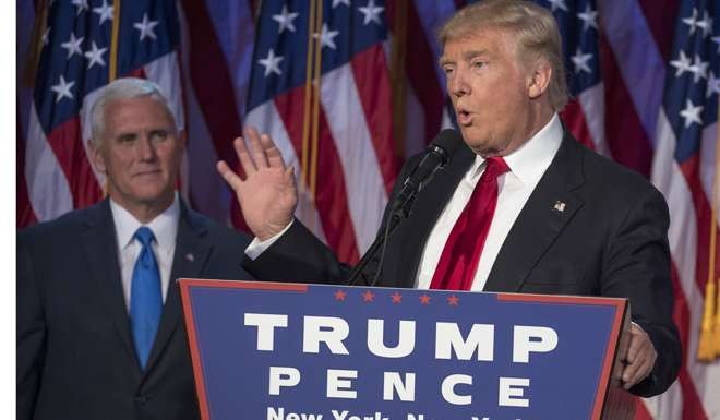 Donald Trump delivers his acceptance speech as running mate Mike Pence looks on, in New York City on November 9. Photo: TNS