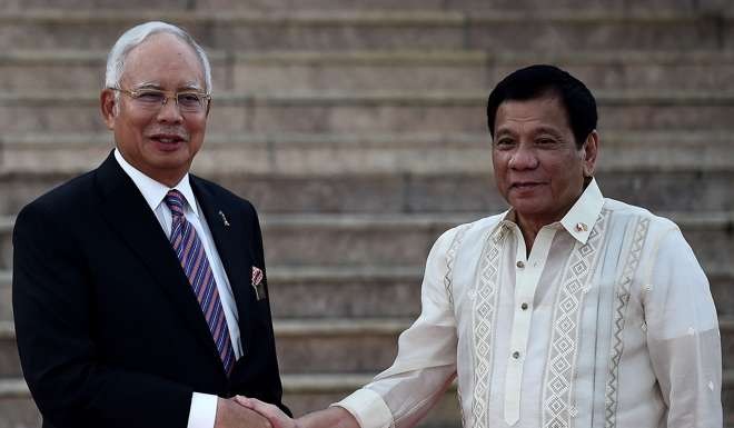 Malaysia's Prime Minister Najib Razak shakes hands with Philippine President Rodrigo Duterte. Photo: AFP