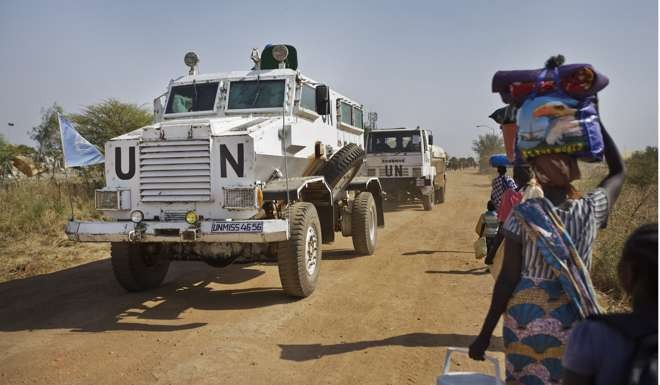 A United Nations armoured vehicle passes displaced people walking towards the UN camp in Malakal, South Sudan. China is the largest contributor of troops to peacekeeping. Photo: AP