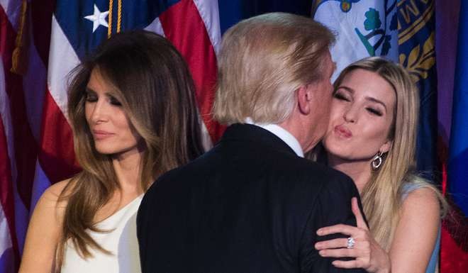 Republican presidential elect Donald Trump (C) kisses his daughter Ivanka Trump (R) as his wife Melania Trump (L) looks on after speaking during election night. Photo: AFP