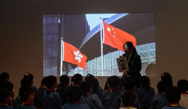 The Hong Kong and national flags are seen during a presentation shown to a group of young pupils attending an educational tour of the Legislative Council in Hong Kong. There is inherent tension in having two highly contrasting legal systems within one country. Photo: AFP