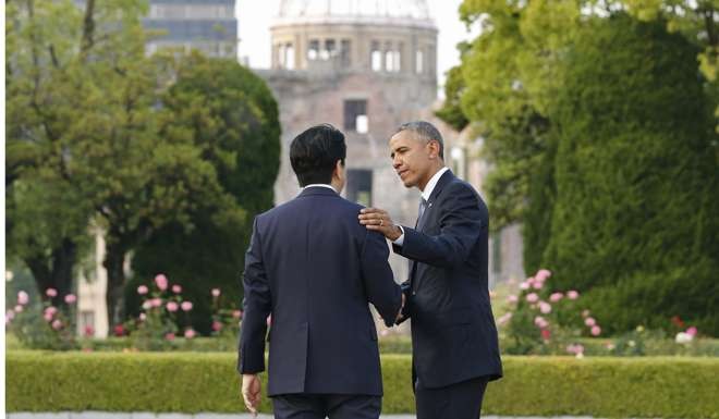 US President Barack Obama speaks to Japanese Prime Minister Shinzo Abe after laying a wreath in front of a cenotaph to offer prayers for victims of the atomic bombing in 1945 at Hiroshima Peace Memorial Park, during a visit to the Japanese city in May this year. Photo: EPA