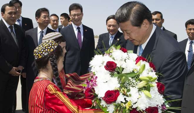 Chinese President Xi Jinping receives flowers upon his arrival in Ashkhabad for a state visit to Turkmenistan, Sept. 3, 2013. (Xinhua/Huang Jingwen)