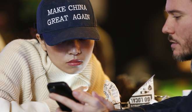 A woman wears a cap with a China message echoing the campaign slogan of US President-elect Donald Trump, “Make America Great Again”, at a bar in Beijing on November 9. Photo: EPA