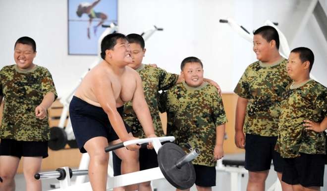 Obese Chinese children exercise in a fitness center during a military training summer camp at the Shenyang Artillery College in Shenyang city, northeast Chinas Liaoning province, 30 July 2009. China faces an obesity epidemic, a senior academic with the release of a report predicting that the worlds most populous country will have 200 million people who are dangerously overweight within the next several years. Image by © Imaginechina/Corbis
