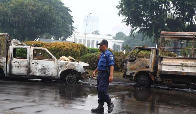 Wrecked police cars in Jakarta in the aftermath of protests against Governor Basuki ’Ahok’ Tjahaja Purnama, who is accused of insulting Islam. Photo: AFP