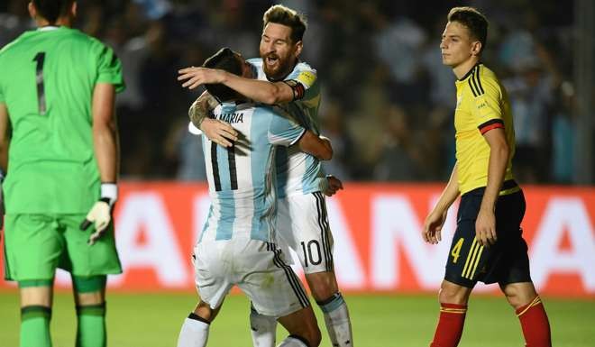 Argentina's Angel Di Maria celebrates with Lionel Messi after scoring against Colombia. / AFP PHOTO / EITAN ABRAMOVICH