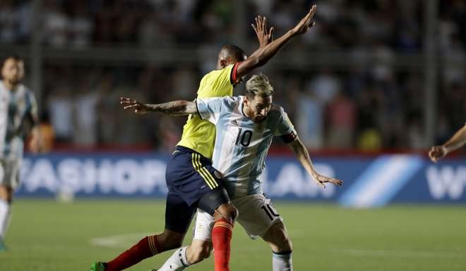 Colombia's Jonathan Copete, left, fouls Argentina's Lionel Messi during a 2018 World Cup qualifying soccer match in San Juan, Argentina, Tuesday, Nov. 15, 2016. (AP Photo/Victor R. Caivano)