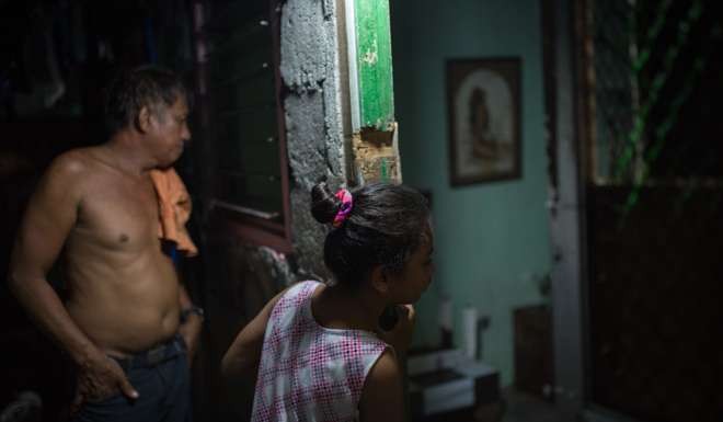 Danilo Mirano and his niece, Casandra, outside the room in which her father used to run a drug den, in Mandaragat. Picture: Paul Ratje