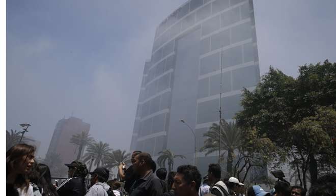 Smoke from a fire billows from a shopping mall next to the hotel that will host world leaders at this week’s Asian-Pacific economic summit. Photo: AP