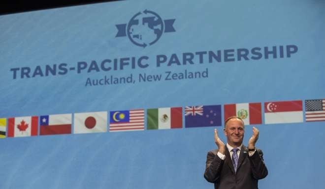 New Zealand Prime Minister John Key claps during the signing of the Trans Pacific Partnership trade agreement in Auckland in February. Key has said the deal was not going to happen anytime soon. File photo: EPA