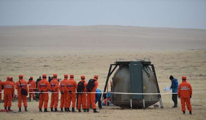 Members of the recovery team surround the landing module on Friday afternoon. Photo: Xinhua