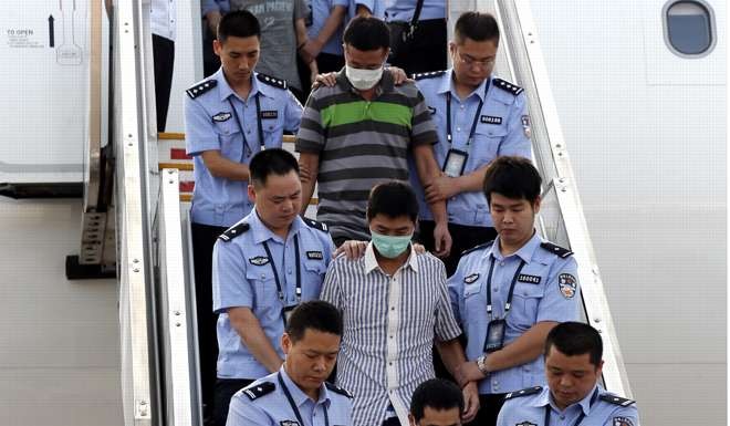 Six fugitives accused of economic crimes are taken back into Chinese custody after being repatriated from Indonesia at Capital International Airport in Beijing. Photo: Xinhua