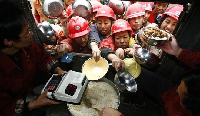 Migrant workers scramble to get lunch at a construction in Yibin, Sichuan province. Many of China’s first generation of migrant workers are nearing retirement age but ineligible for pensions. Photo: Reuters